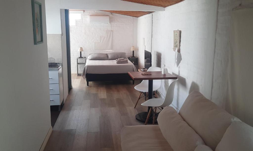 梅塞德斯Confortable apartamento-monoambiente en Mercedes的客厅配有床、沙发和桌子