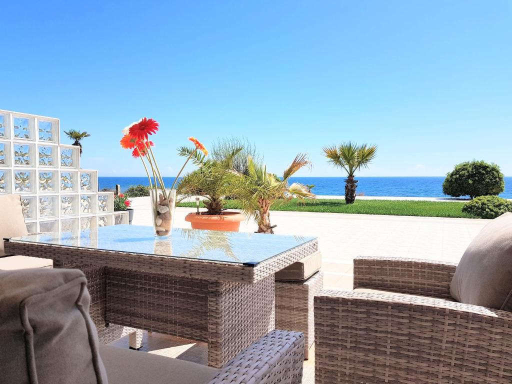 亚历山德鲁波利斯Villa Alexandros的一个带桌椅的庭院和大海