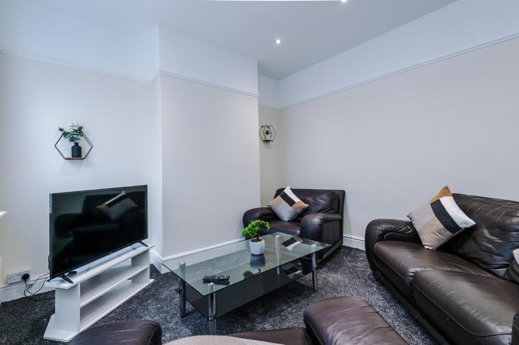 利物浦Cosy Modern 3-BR Apartment - Sleeps 5的客厅配有两张真皮沙发和一台电视机