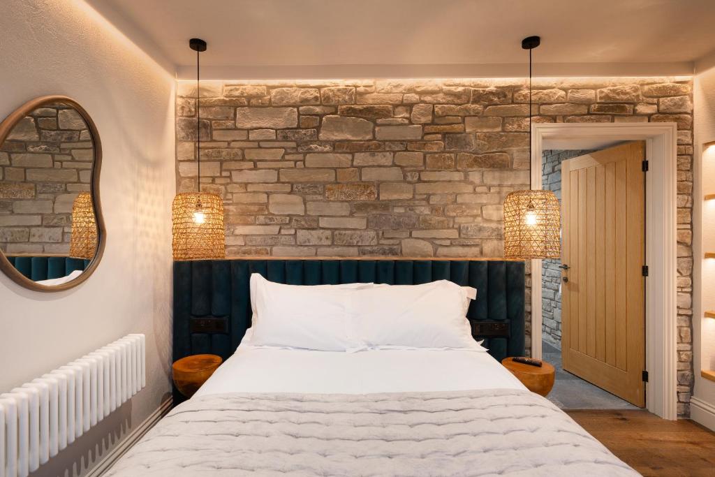 阿博伦Hive Townhouse的一间卧室设有一张床和砖墙