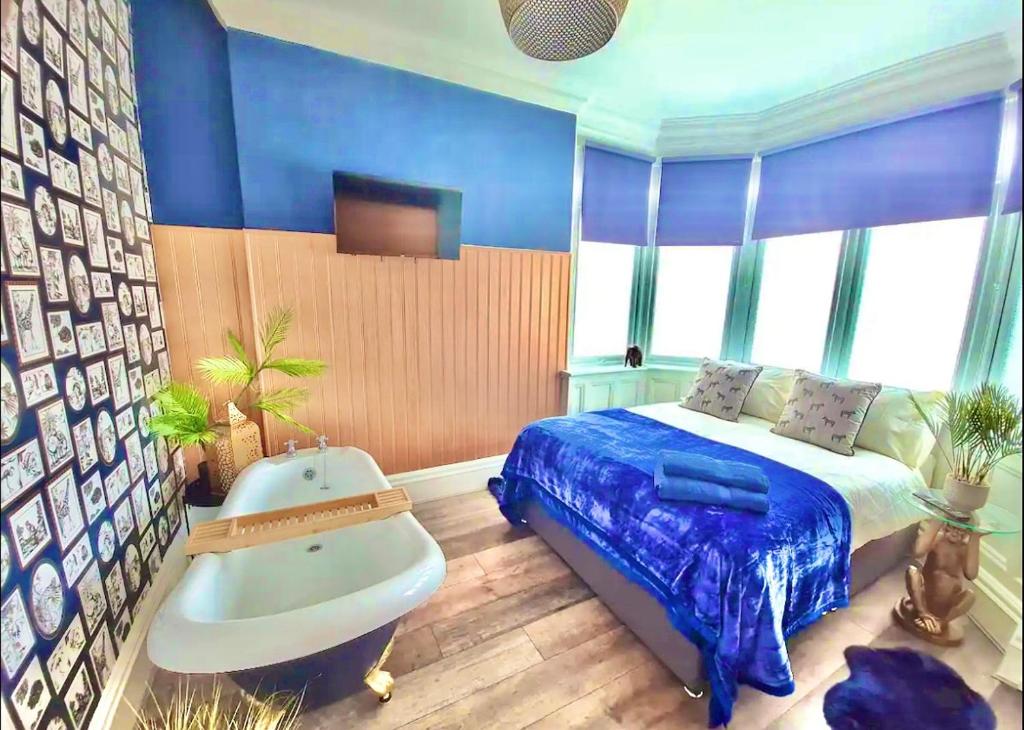 伯恩茅斯Blue Cheetah Lemur Lodge的一间卧室配有一张床、一个浴缸和一个浴缸