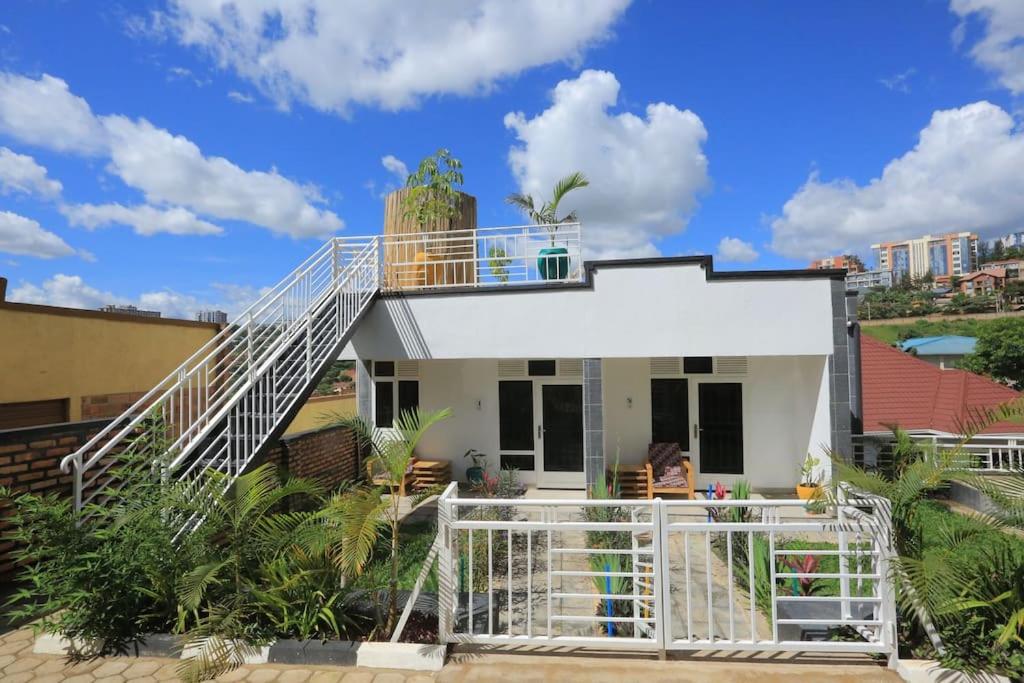 基加利Style and Comfort Full Kigali Rwanda Apartment的一座白色的小房子,前面有楼梯