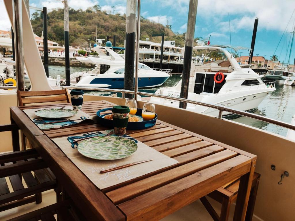 巴拿马城Amazing Vintage Yacht in the best area of Panama!的船上的一张木桌,上面放着食物