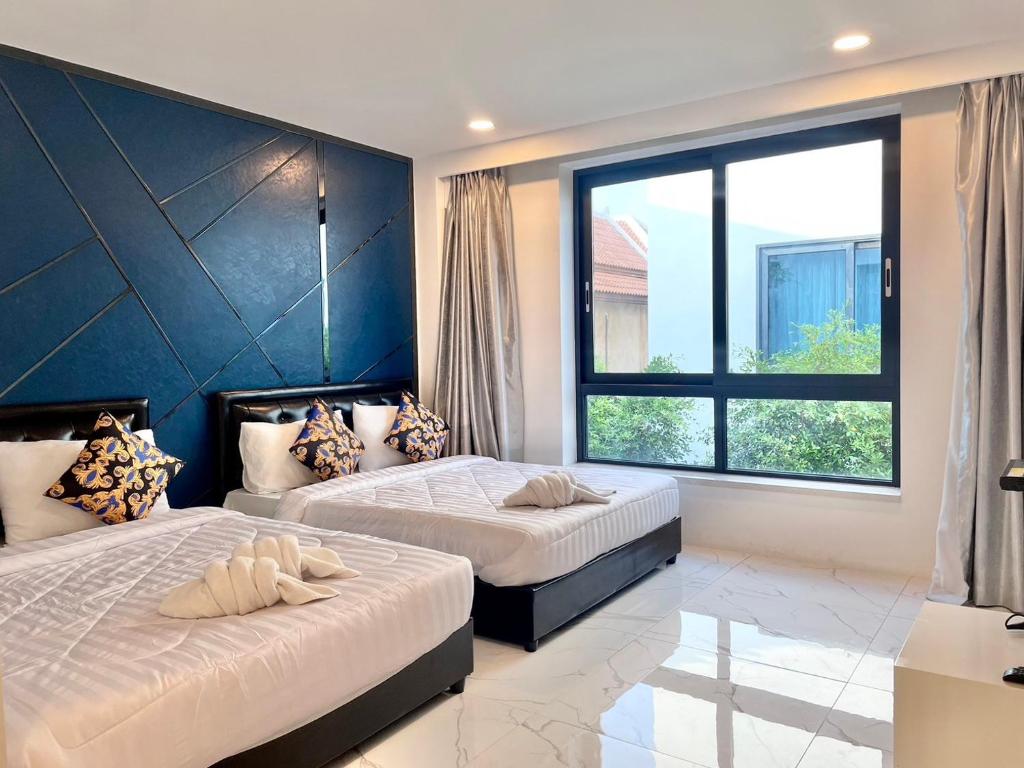 南芭堤雅Pupae Pool Villa Pattaya的一间卧室设有两张床和大窗户