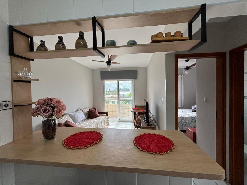 大普拉亚Apto dos Cardeais的厨房里摆放着红色鲜花的桌子