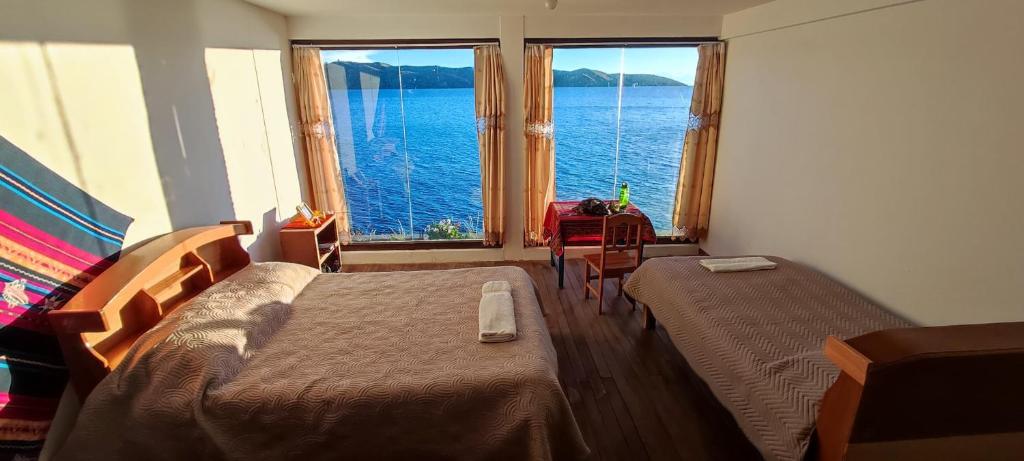Isla de la LunaWaynapicchu Lodge Isla de la Luna Bolivia的一间卧室设有两张床,享有水景