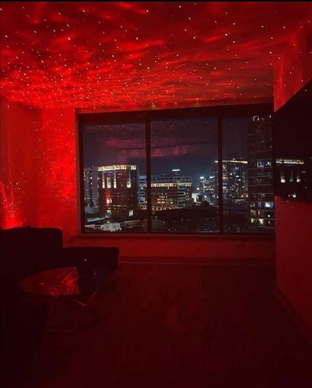 拉巴斯SpicyGameRoom的红色客房,设有窗户,享有城市美景