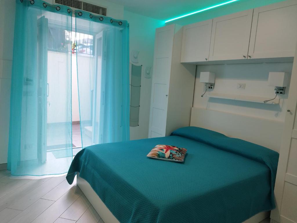 普罗奇达SoleMare Rooms "Smeraldo"的一间蓝色卧室,配有一张带书籍的床