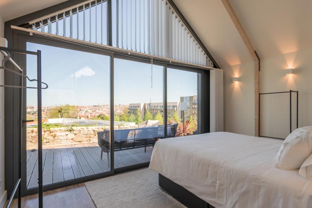 加亚新城FONTE SANTA Manor House的一间卧室设有一张床和一个大型玻璃窗