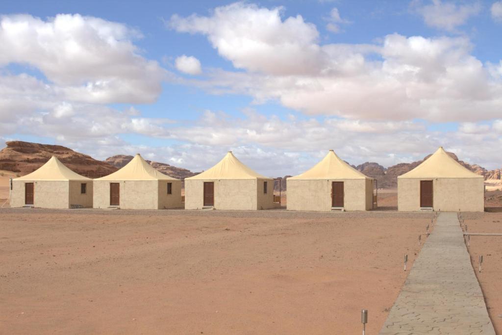 DisahRemal Wadi Rum Camp & Tour的一片云天下沙漠中的一排帐篷