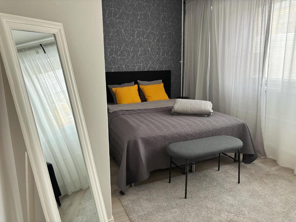 哈米纳Hamina City Apartments的一间卧室配有一张带黄色枕头和椅子的床