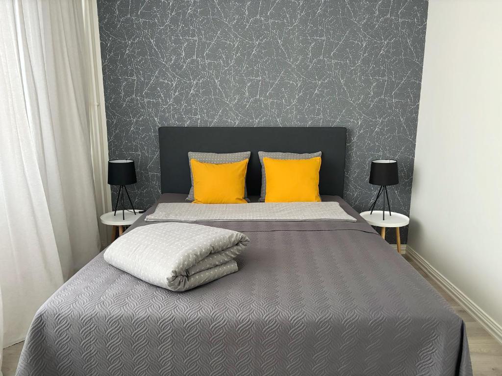 哈米纳Hamina City Apartments的一间卧室配有一张带两个黄色枕头的床