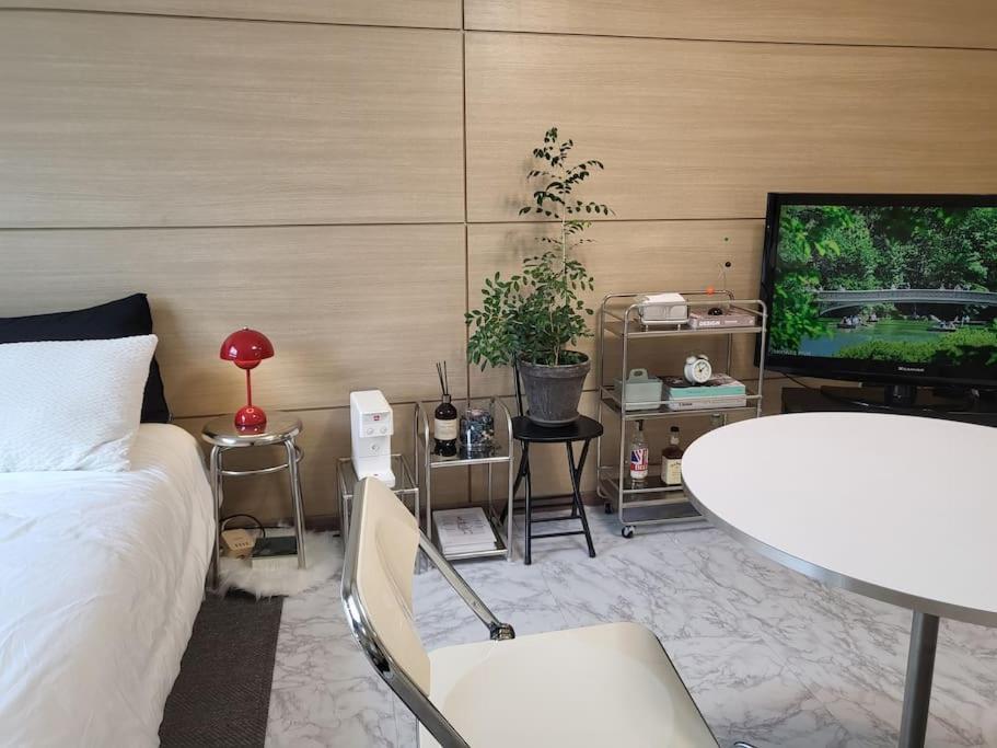 束草市Sokcho Coco的一间卧室配有一张床、一张桌子和一台电视。