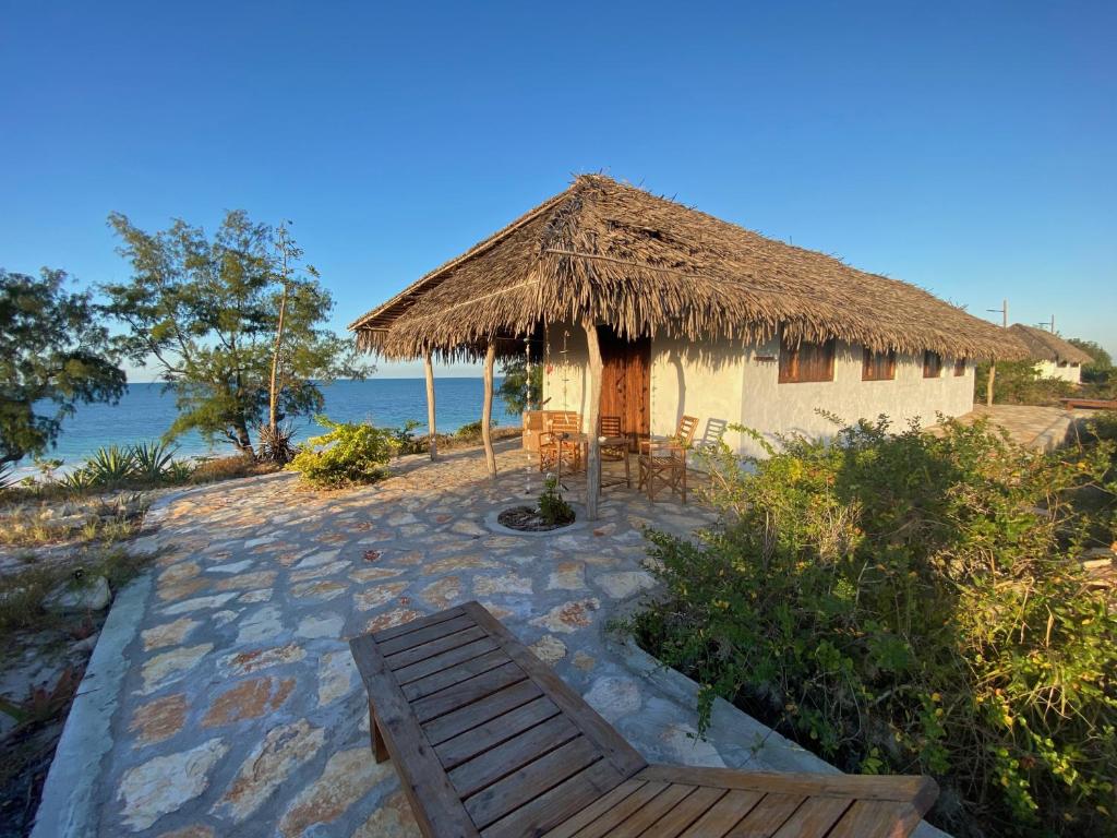 MossurilNamahamade Lodge Restaurante & Beach Bar的一个带长凳和茅草屋顶的小小屋