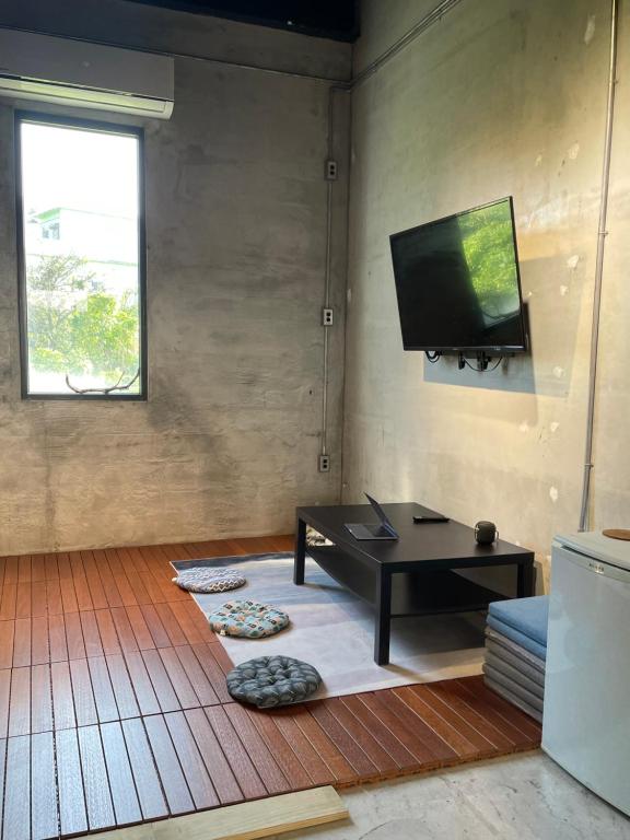 绿岛COOLFREEDIVING Hostel的客厅配有桌子和平面电视。