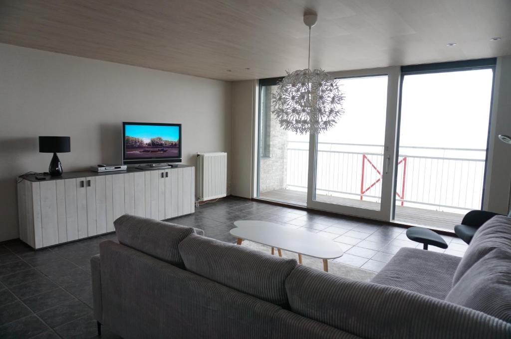 布雷斯肯斯Kustverhuur, Prachtig appartement met uitzicht op zee, Port Scaldis 09-051的带沙发和电视的客厅