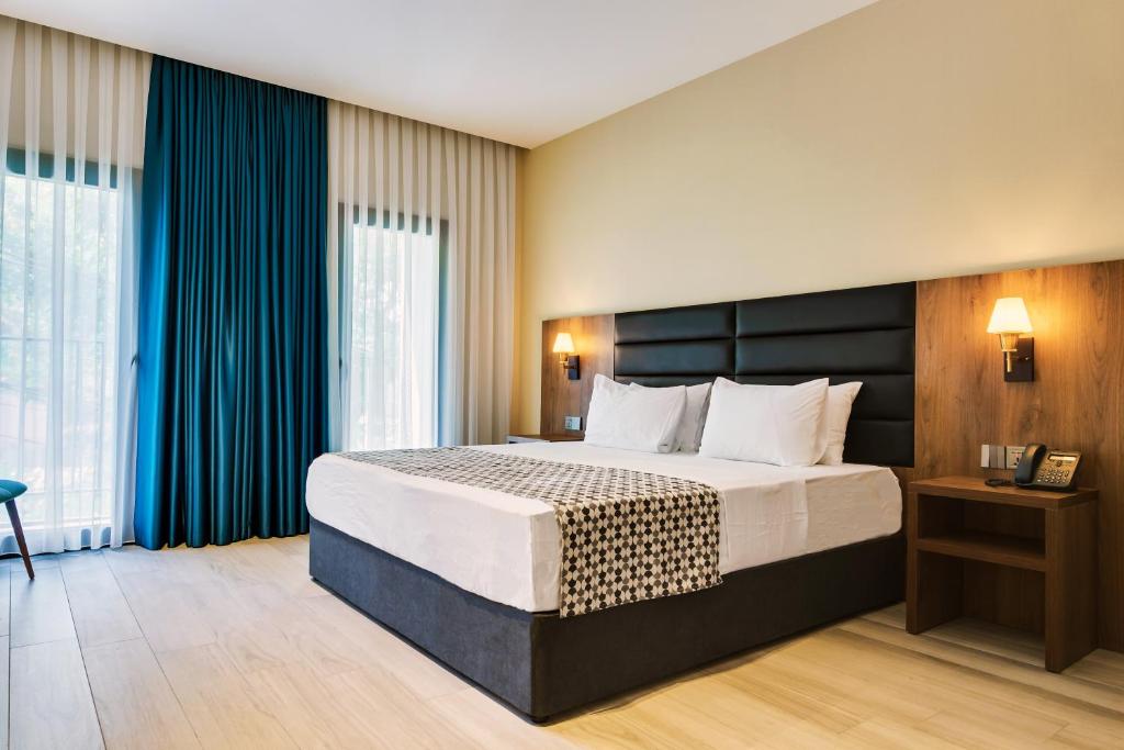 第比利斯Eleven Inn Tbilisi的一间卧室配有一张带蓝色窗帘的大床