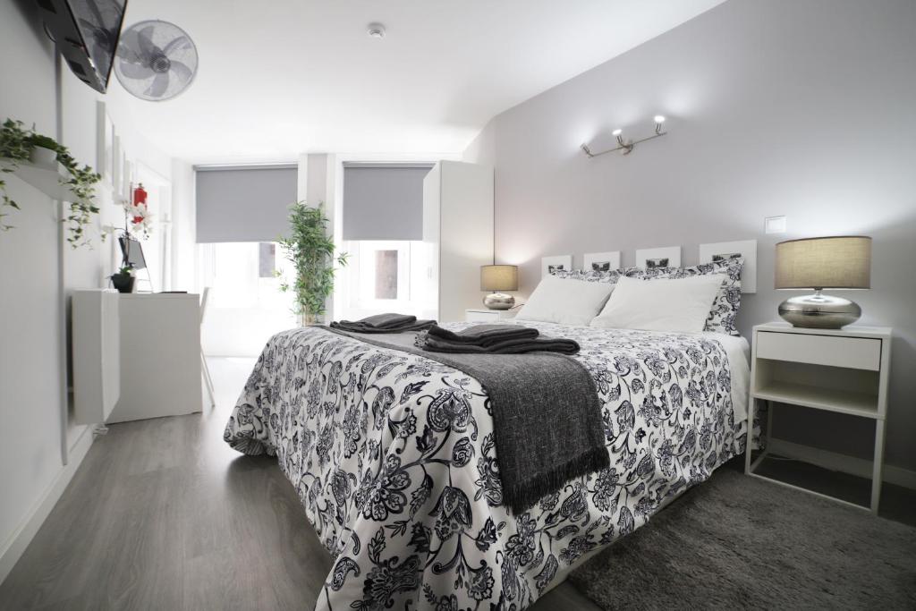 波尔图Guest House Triunfo的一间卧室配有一张带黑白色床罩的床。