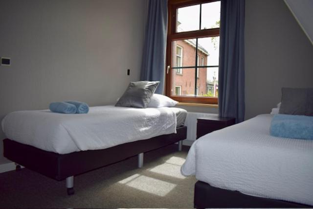 温斯霍滕Hotel Restaurant 't Ronde Loegh的一间卧室设有两张床和窗户。