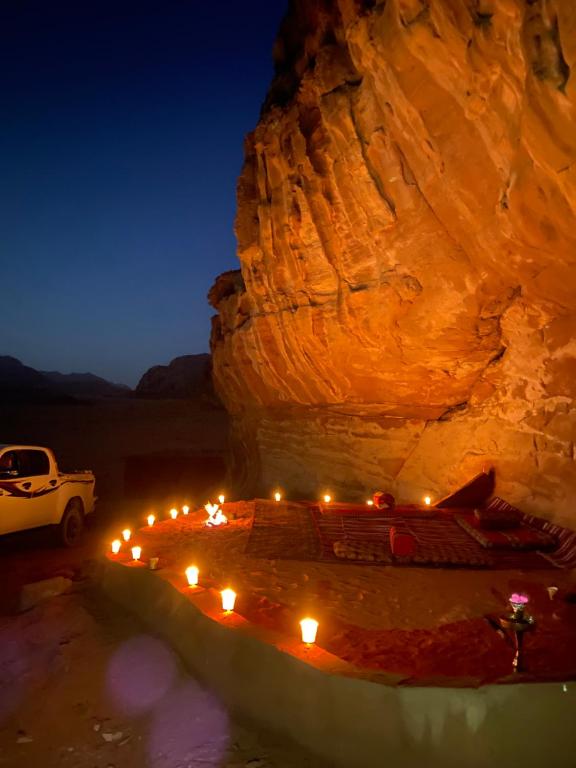 瓦迪拉姆Wadi Rum Story Camp的岩石前灯火通明的洞穴内的一张床位