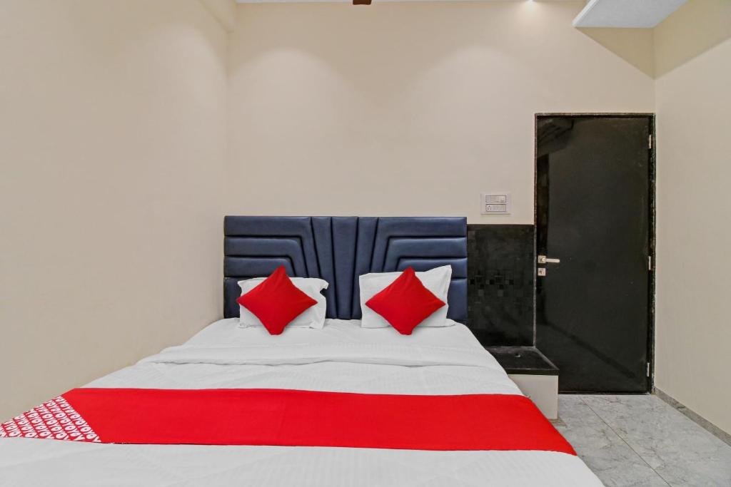 SakardarāFlagship Hotel S R Guest House的一间卧室配有红色和白色枕头的床