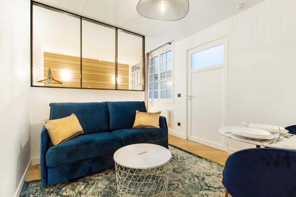 巴黎Chic Apartment in the Prestigious Saint Honoré的客厅配有蓝色的沙发和桌子