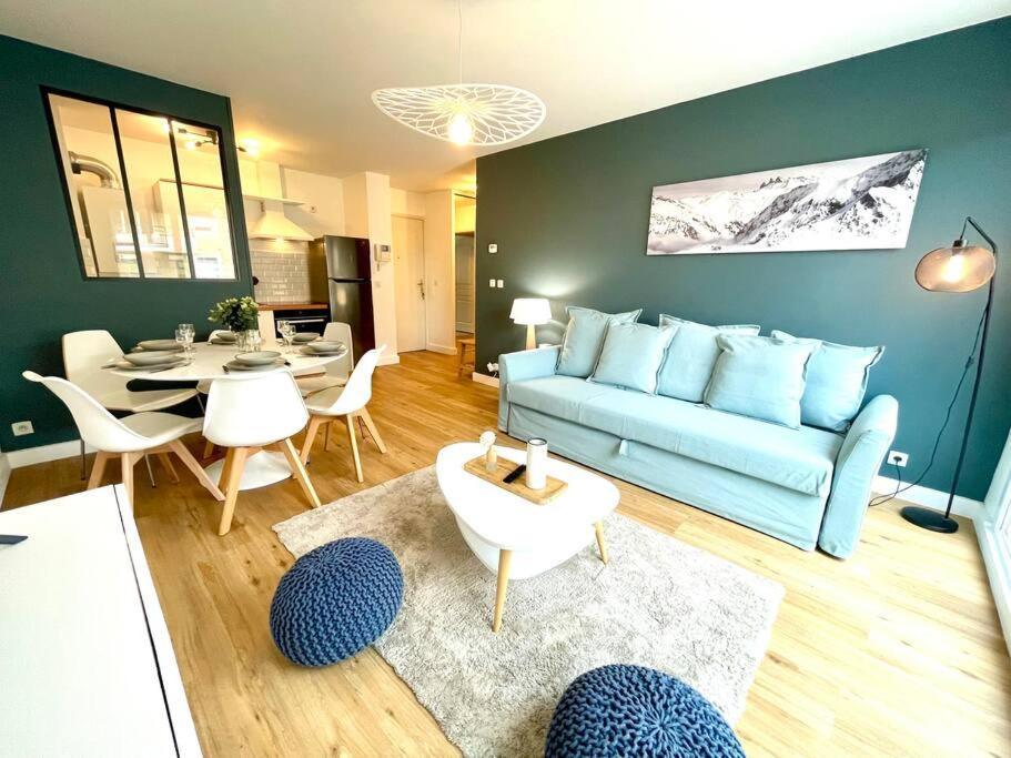圣热尼普伊Le Familial - Terrasse - Proximité Genève的客厅配有蓝色的沙发和桌子