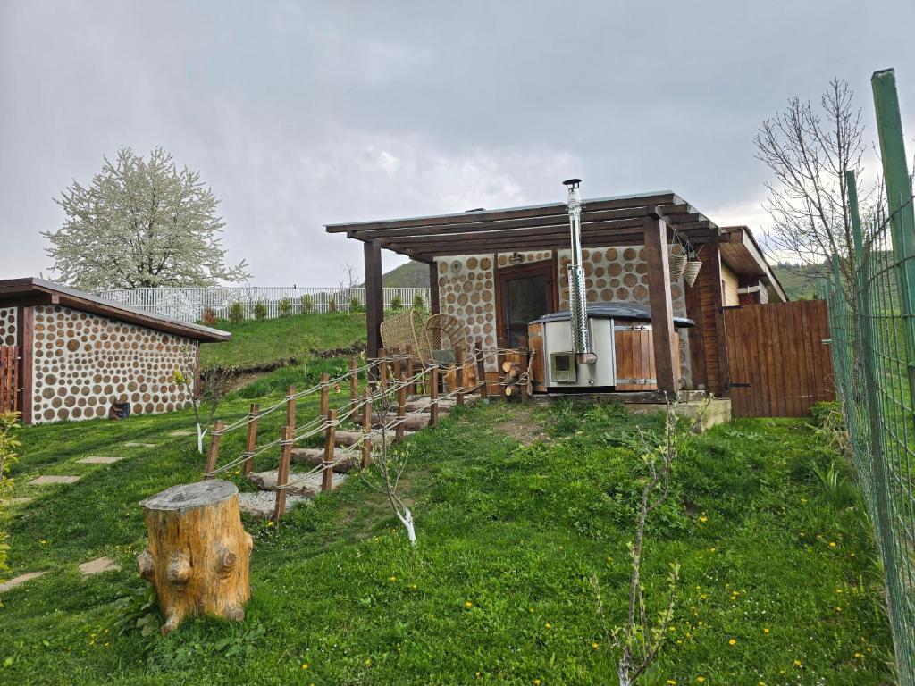 布泽乌河畔瓦马乡Cazare Vama Buzaului la Vama Aniral的一座带围栏的田野上的砖房