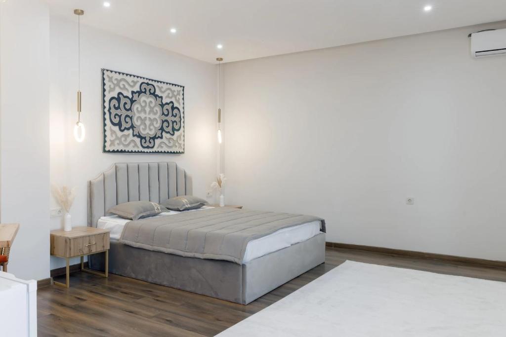 阿斯塔纳Tumar Hansa Ethno Hotel的白色卧室配有床和桌子
