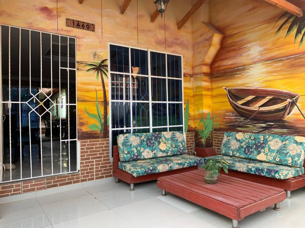 塔甘加Hostal Buena Vida的一间设有两张沙发的房间和墙上的绘画