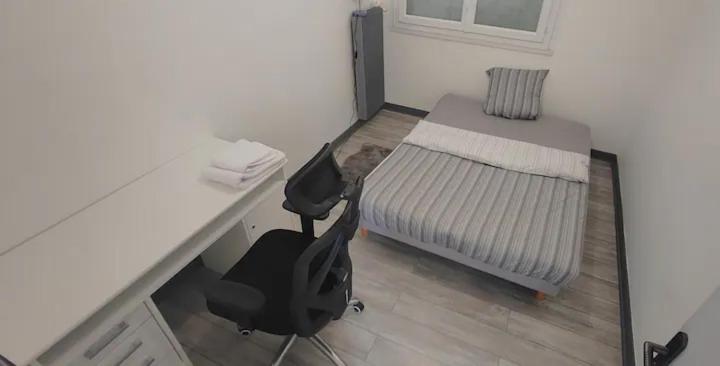 格勒诺布尔Une Chambre dans Appartement - Grenoble, France à 8 min du centre-ville的一间卧室配有书桌、一张床和一把椅子