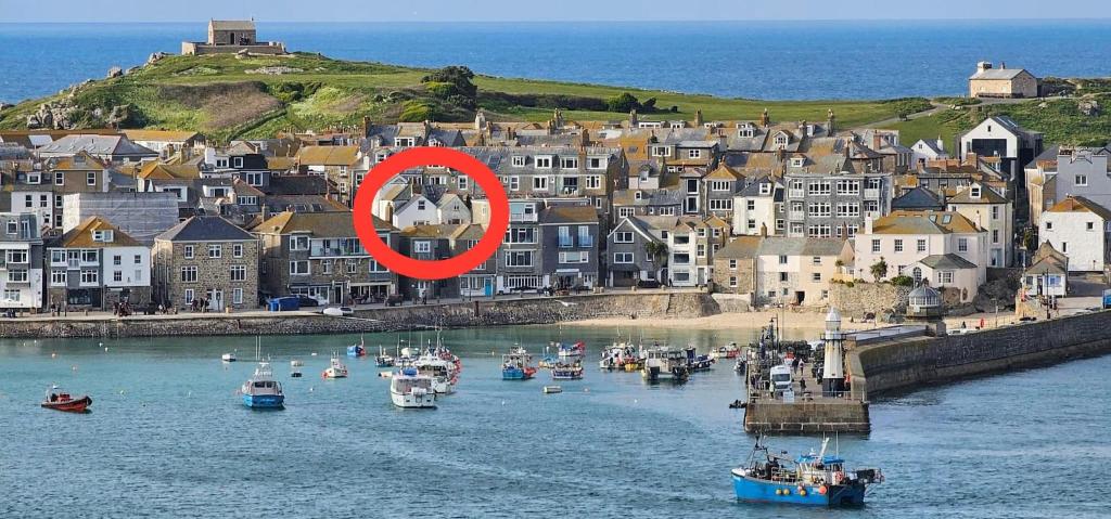 圣艾夫斯AMAZING LOCATION - "SMUGGLERS HIDE" & "SMUGGLERS CABIN" - a 2 BEDROOM FISHERMANS COTTAGE with HARBOUR VIEW and also a private entrance 1 BED STUDIO - 10 Metres To Sea Front - BOOK BOTH for ENTIRE 3 BEDROOM COTTAGE - 2023 GLOBAL REFURBISHMENT AWARD WINNER的一群小船在城附近的水里