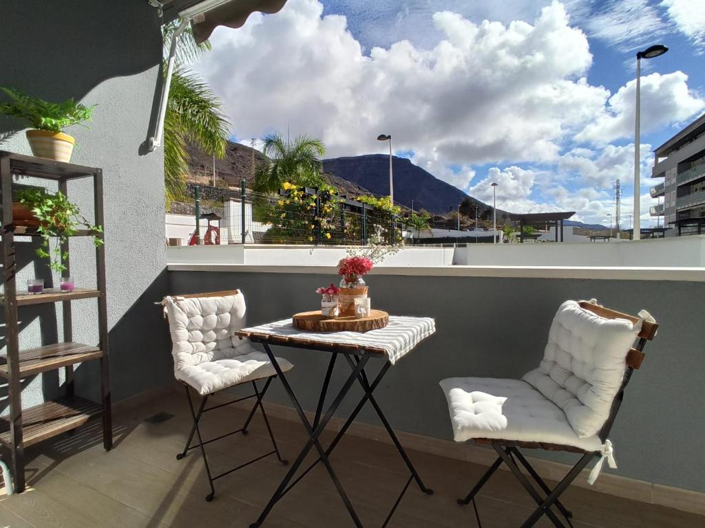 巴哈马尔Apartamento Bajamar Tenerife的阳台配有一张小桌子和两把椅子