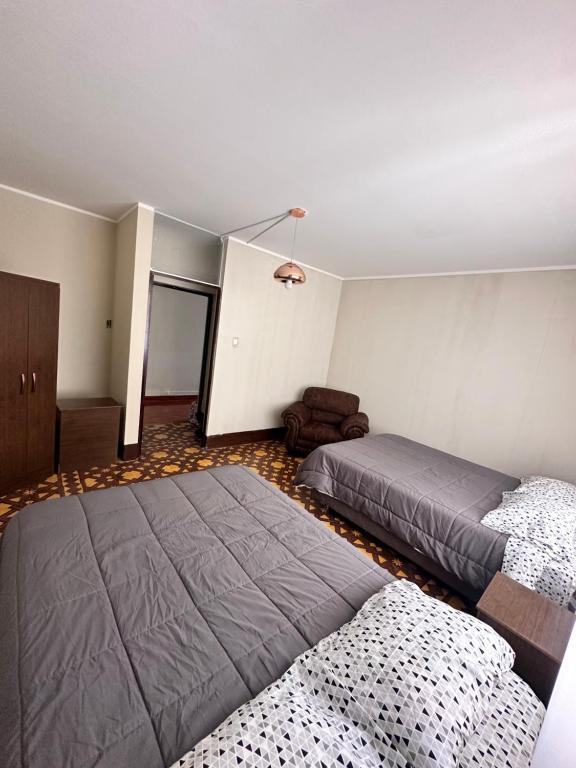 阿亚库乔CASTELLARES LA PUEBLA APARTAMENT的一间卧室配有两张床和椅子