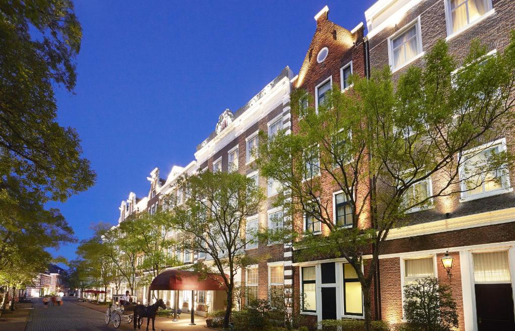 佐世保Hotel Amsterdam Huis Ten Bosch的前方树木林立的街道上的建筑