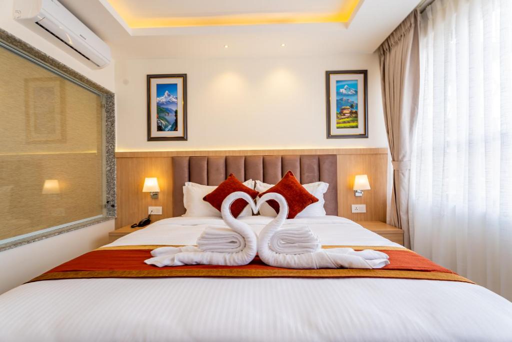 加德满都Hotel Crystal Pashupati的床上的2条白色天鹅毛巾