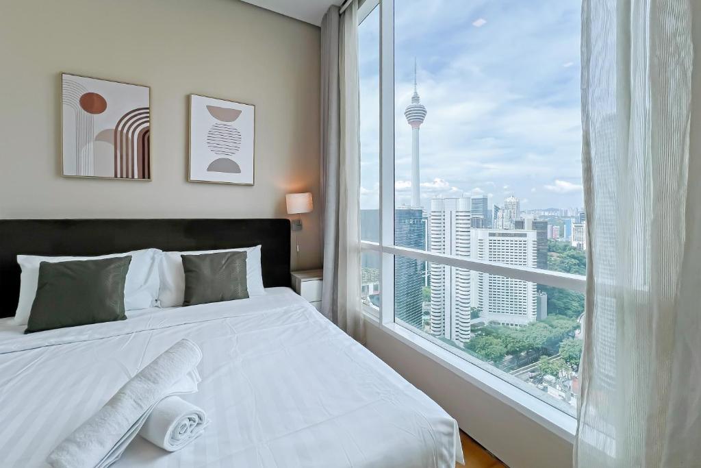 吉隆坡Soho Suites KLCC by GuestHouse的卧室设有白色的床和大窗户