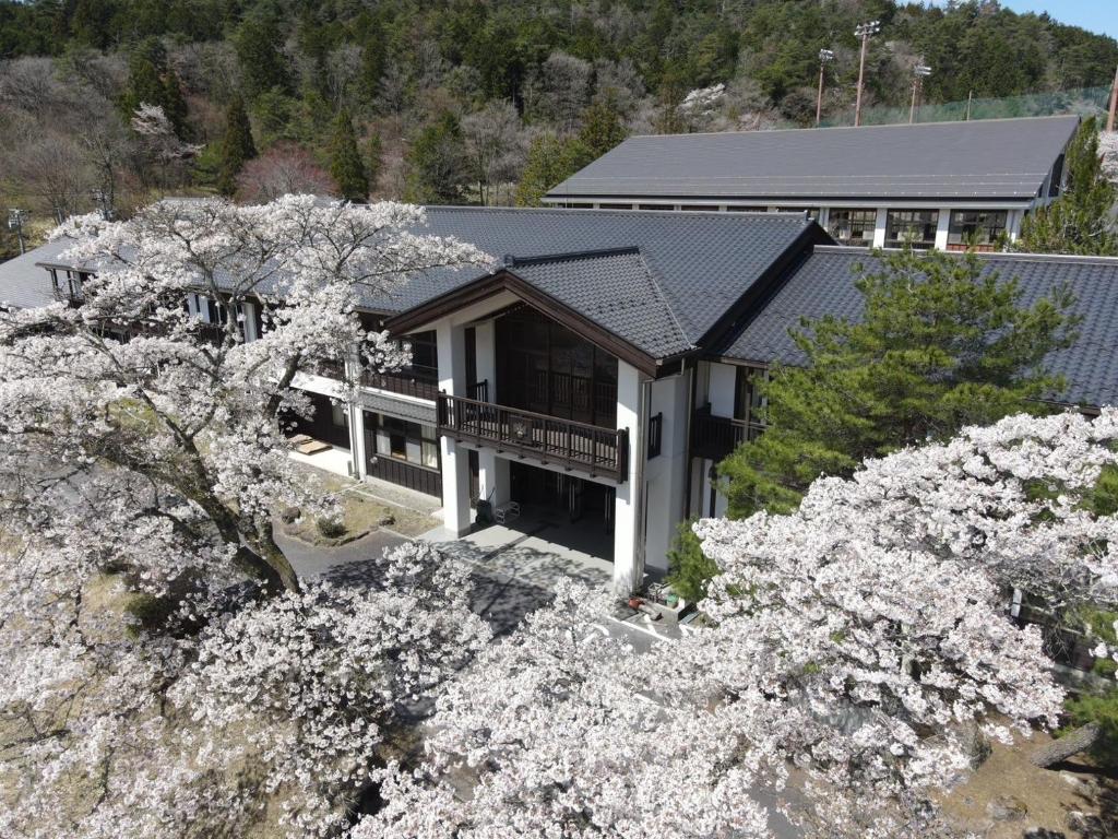 中津川市馬籠ふるさと学校 Magome Furusato Gakkou的享有一所拥有樱树的房子的空中景致