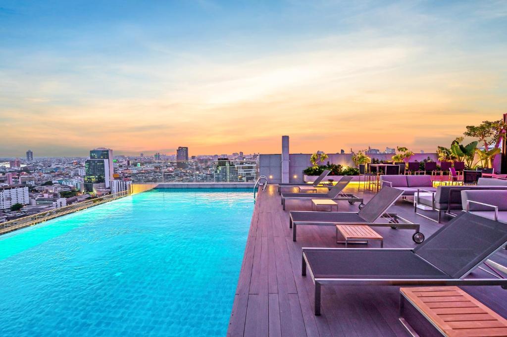 曼谷Amara Bangkok Hotel的一座城市建筑顶部的游泳池