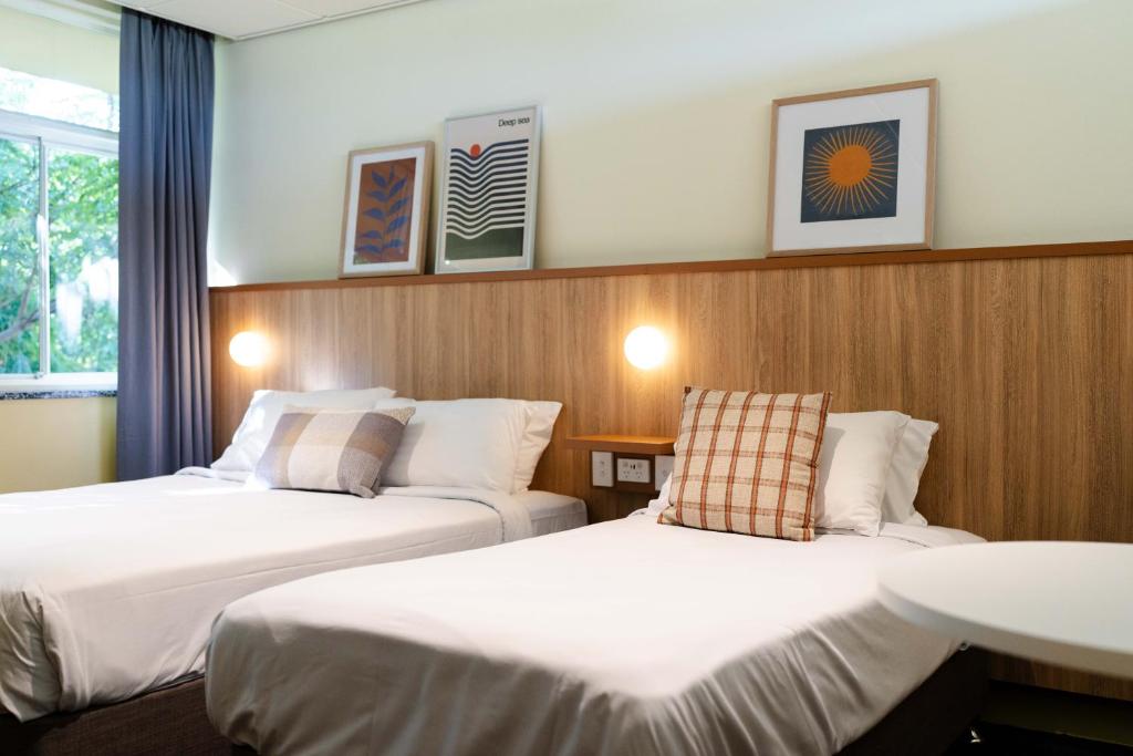 BrightonBrighton Hotel的酒店客房设有两张床和盥洗盆