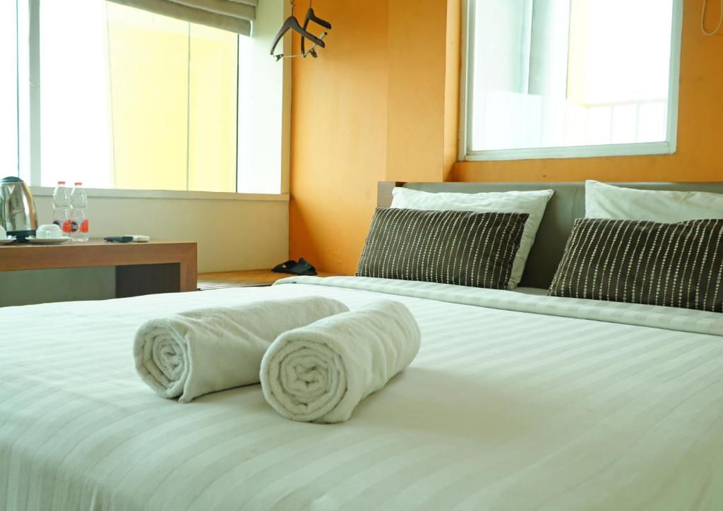 雅加达World Hotel Jakarta - Bandengan的房间里的床上有两条白色毛巾