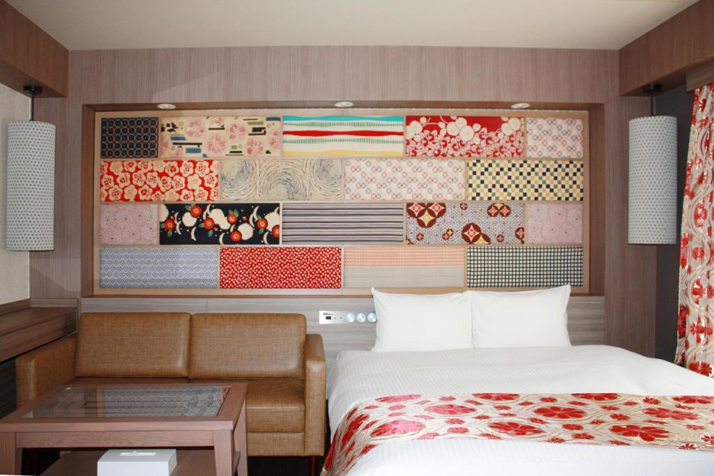 大阪hotel VR osaka的一间卧室配有一张床,墙上挂着绘画作品