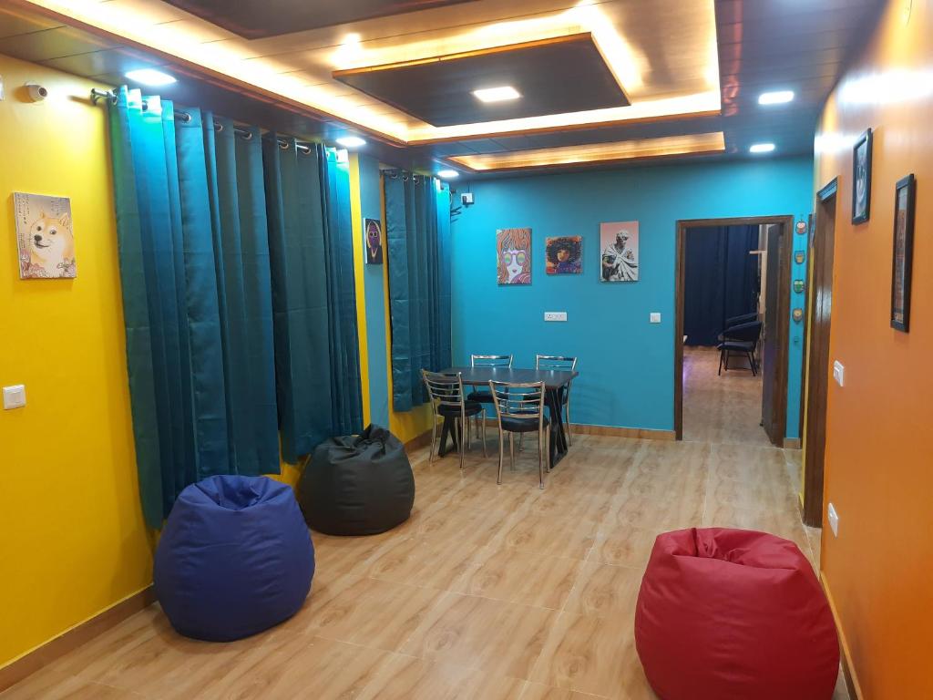 西姆拉Aagaman Woods Homestay的配有桌椅和蓝色墙壁的客房