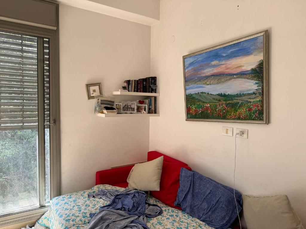 纽约Pretty home的卧室配有一张床,墙上挂有绘画作品