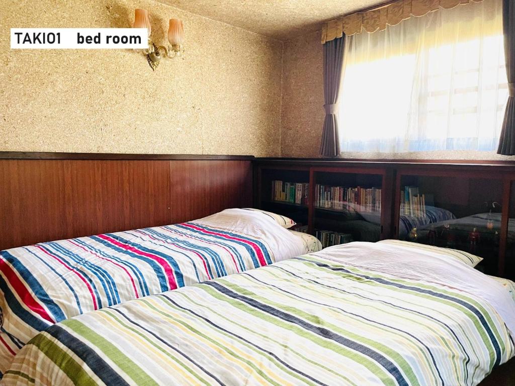 东大阪市TAKIO Guesthouse - Vacation STAY 06377v的卧室内两张并排的床