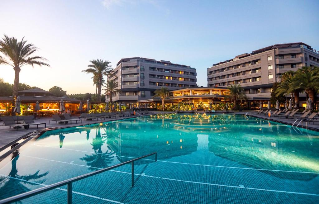 锡德Miramare Beach Hotel - Ultra All Inclusive的两栋建筑前的大型游泳池