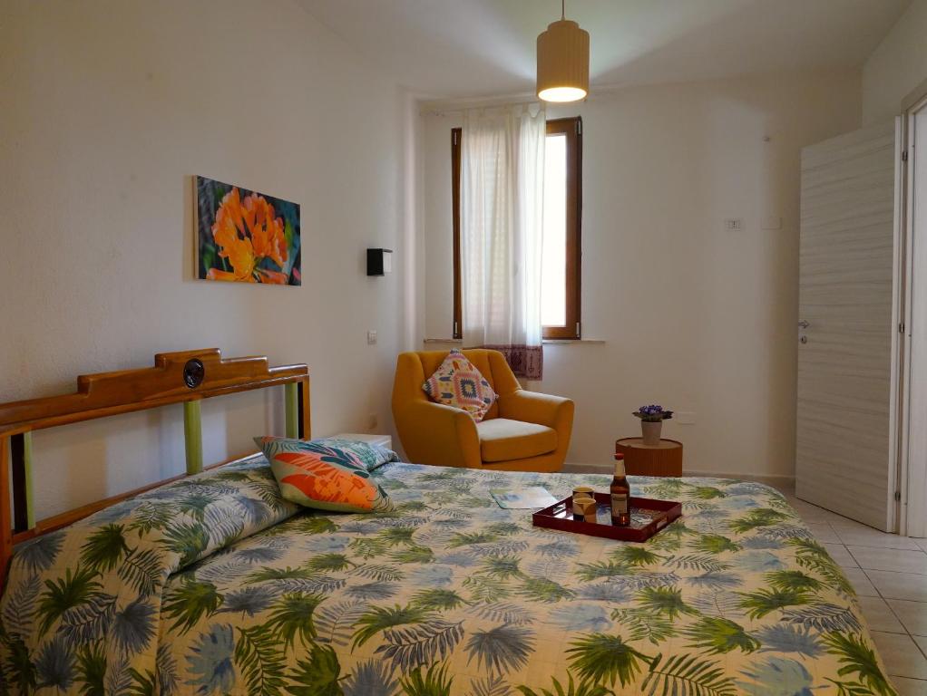 阿尔盖罗花卉别墅旅馆的一间卧室配有一张床和一把椅子