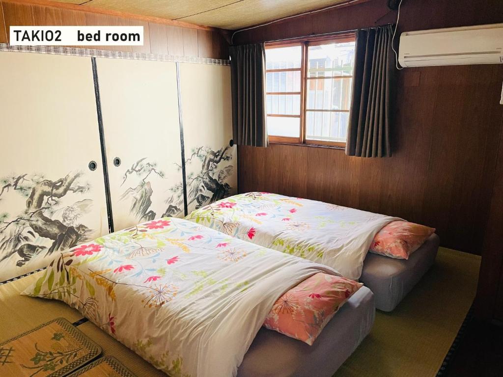 东大阪市TAKIO Guesthouse - Vacation STAY 11600v的一间卧室设有两张床和窗户。