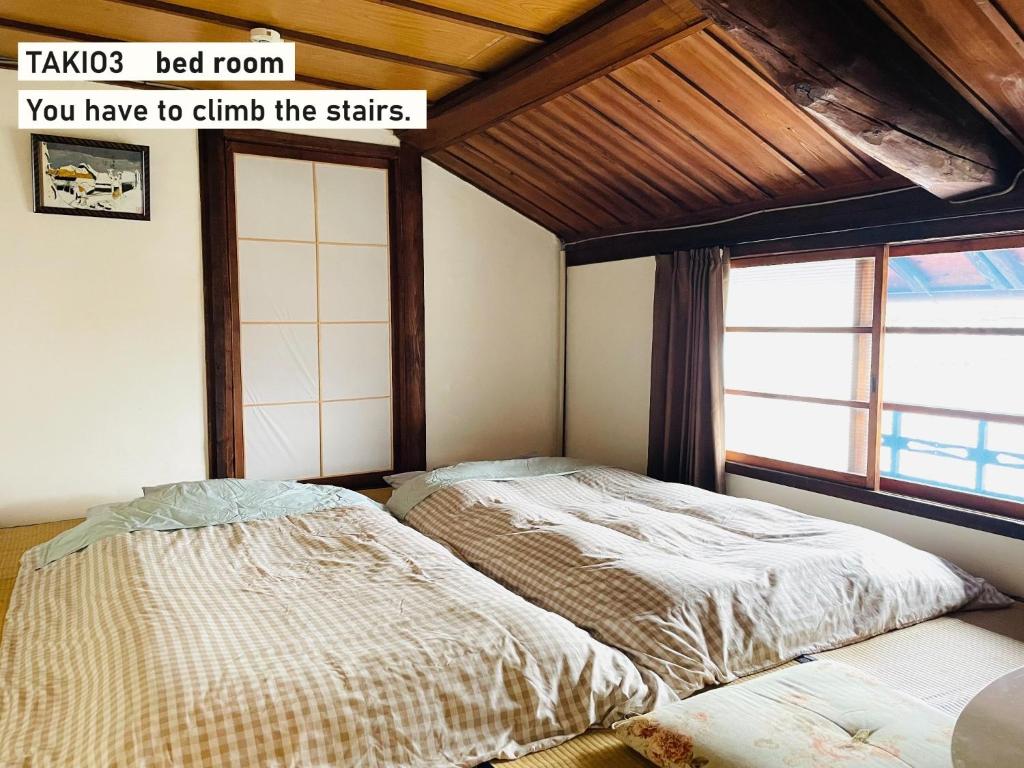 东大阪市TAKIO Guesthouse - Vacation STAY 11604v的一间卧室设有两张床和窗户。