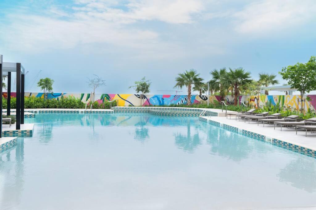 迪拜2 BR Condo in Aykon City Tower - Business Bay的度假村的游泳池,带椅子和游乐场